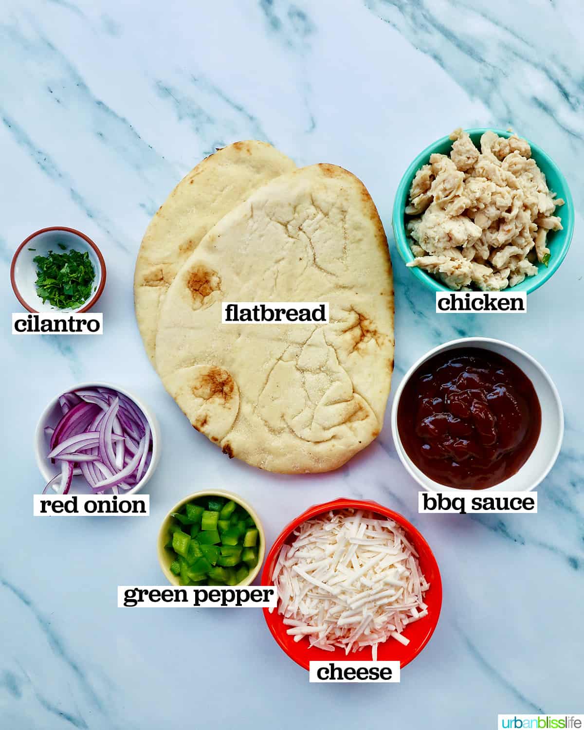 ingredients to make barbecue chicken flatbread pizza on marble.