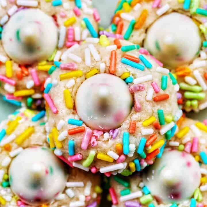 several spring almond sprinkle cookies stacked on top of one another.