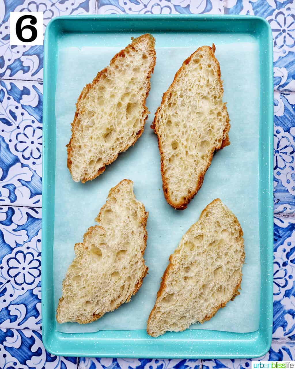 croissants split in half on a baking sheet.