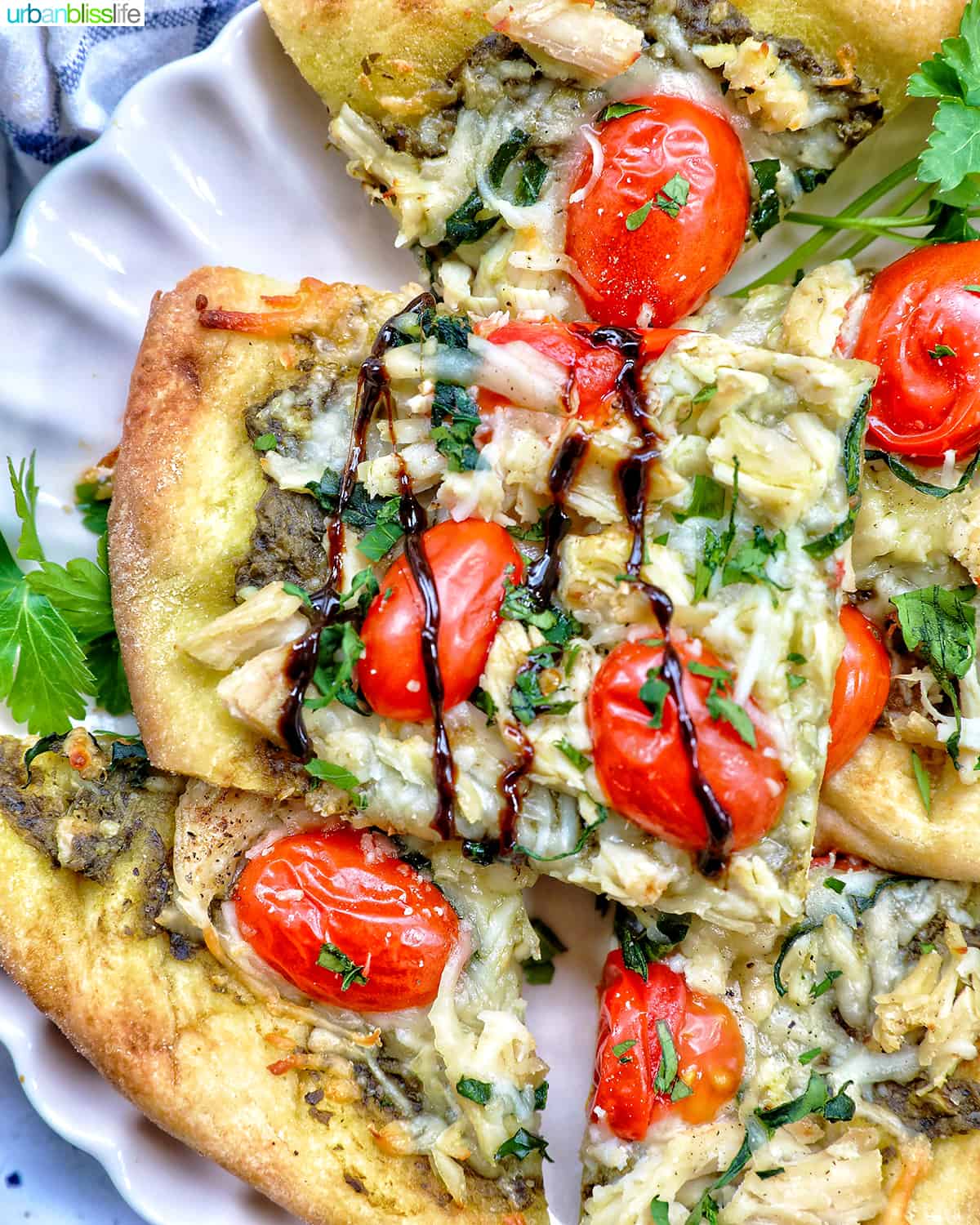 slices of chicken pesto flatbread on a plate, with balsamic drizzle.