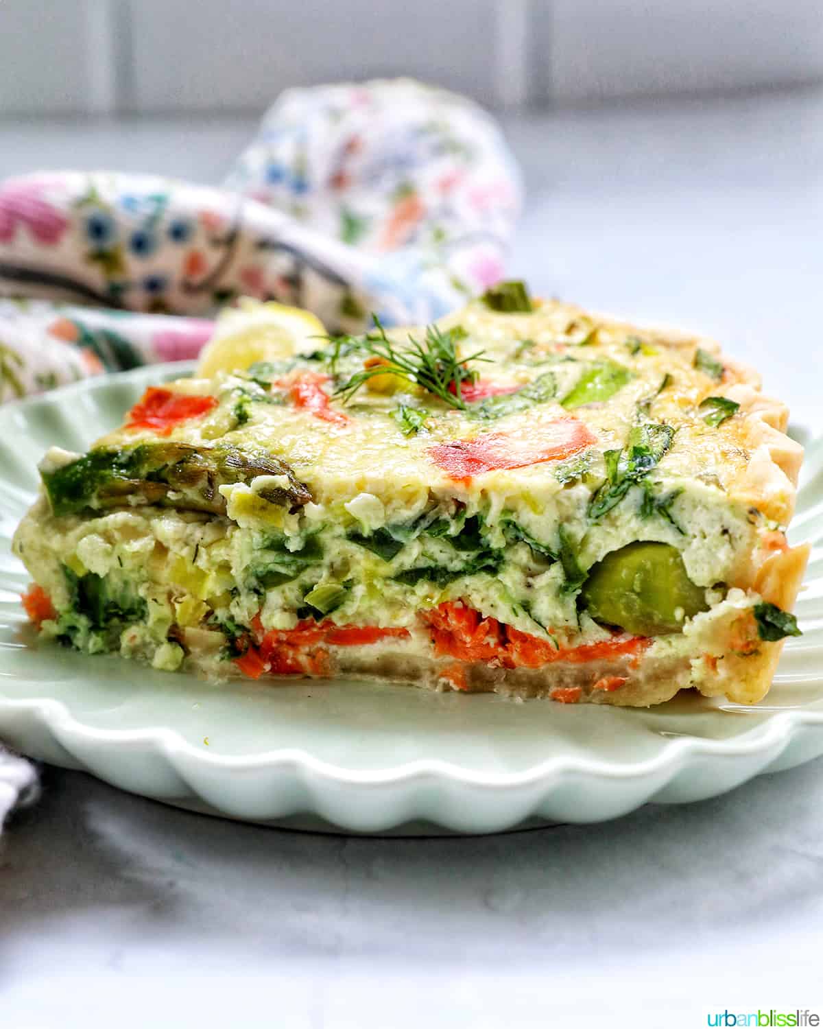 slice of salmon quiche on a plate with the center exposed.