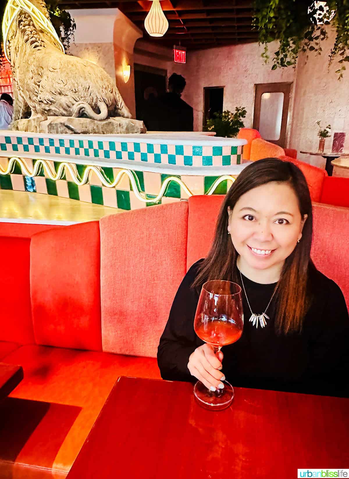 Marlynn Jayme Schotland holding a glass of non-alcoholic wine at Bad Roman restaurant in New York City.