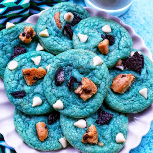 plate of bright blue cookie monster cookies with glass of milk.