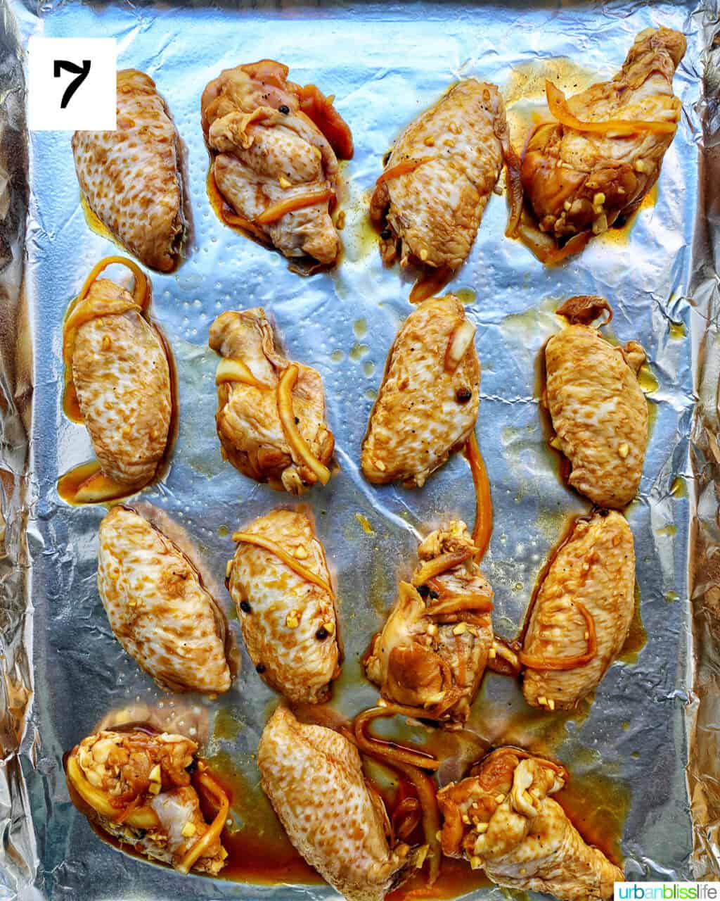 adobo chicken wings on an aluminum foil-covered baking sheet.