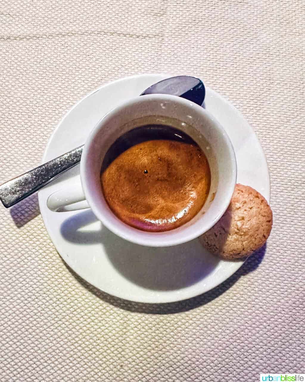 cup of expresso, spoon, little cookie  at Marea restaurant New York City (NYC).