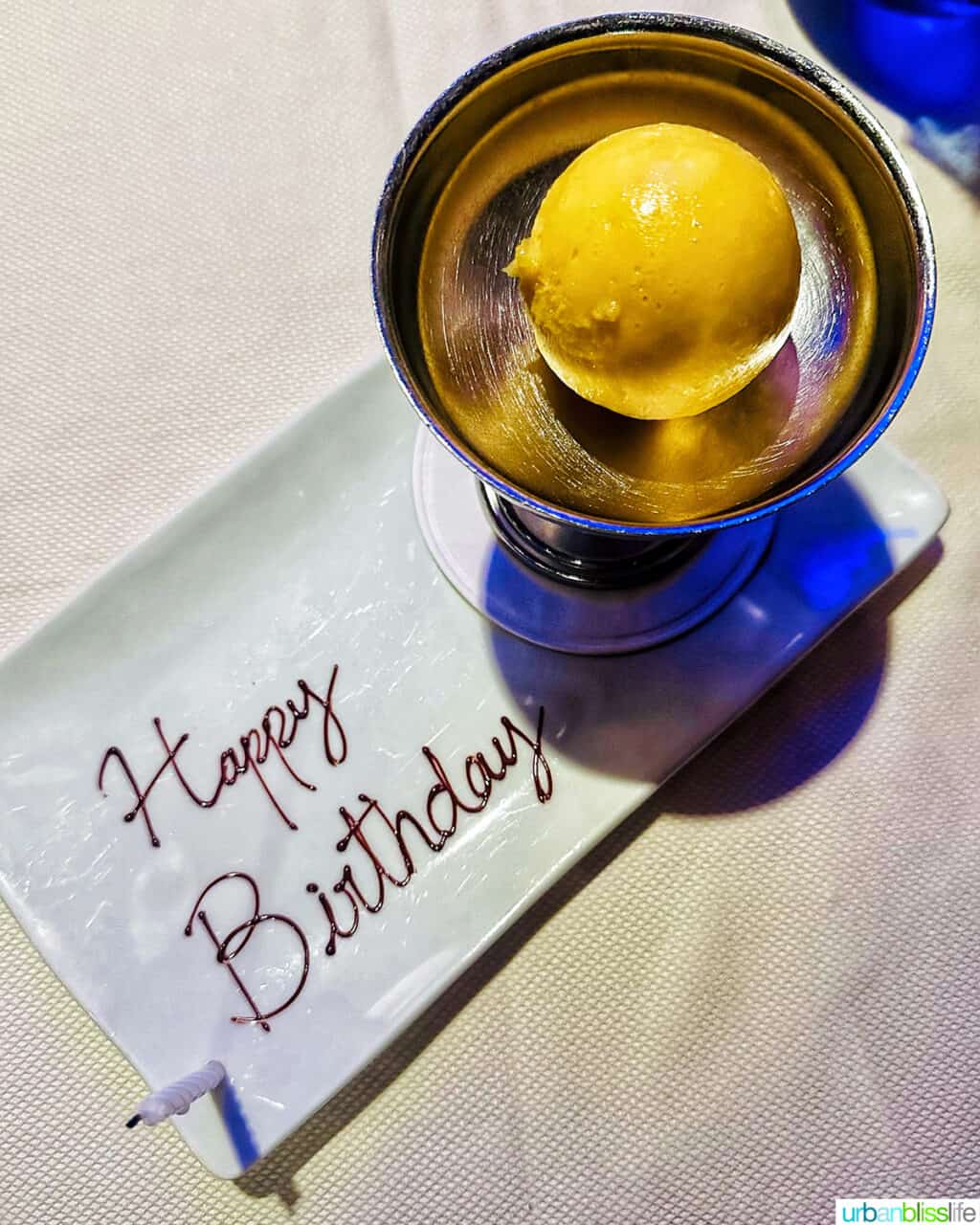 yuzu sorbet in a bowl with a plate that has Happy Birthday written in chocolate  at Marea restaurant New York City (NYC).