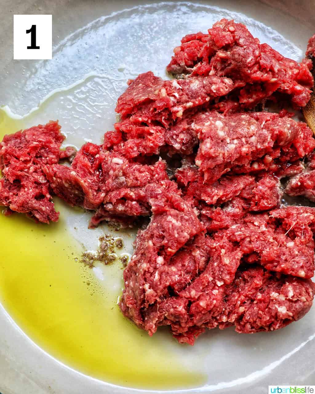 ground beef and olive oil cooking in a pan.
