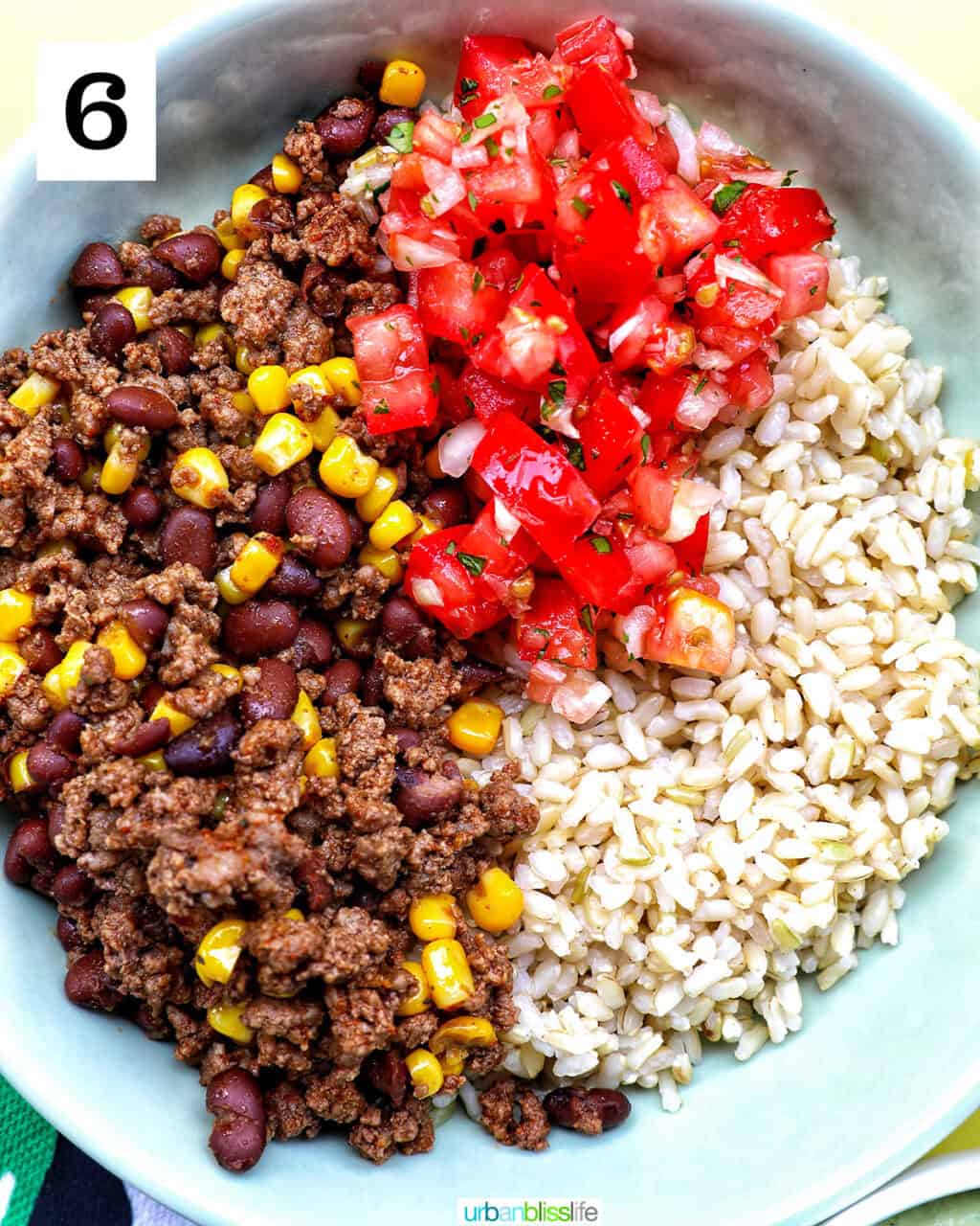 taco bowl of brown rice, beef, beans, corn, tomatoes.