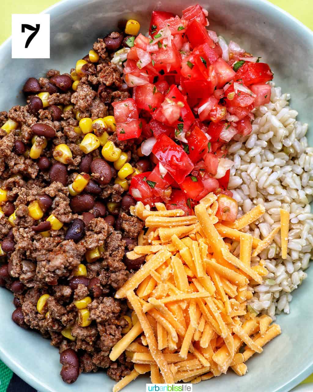 taco bowl of brown rice, beef, beans, corn, tomatoes, cheese.
