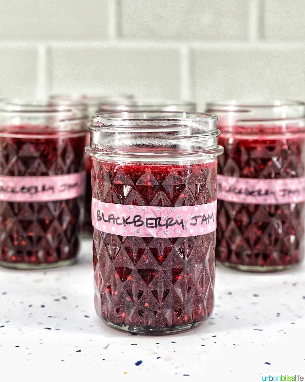 mason jars filled with blackberry freezer jam.