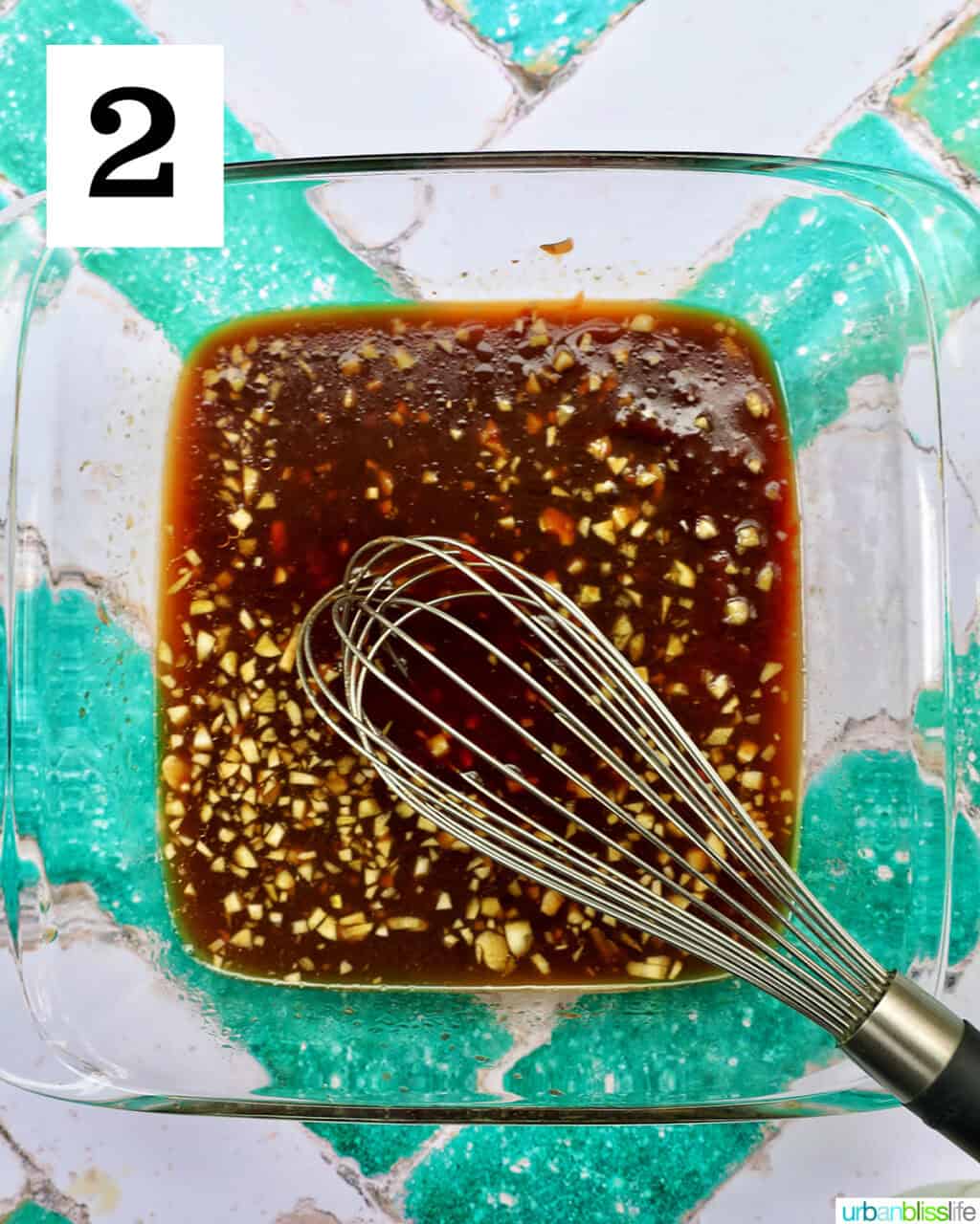 whisk with BBQ sauce in a dish.