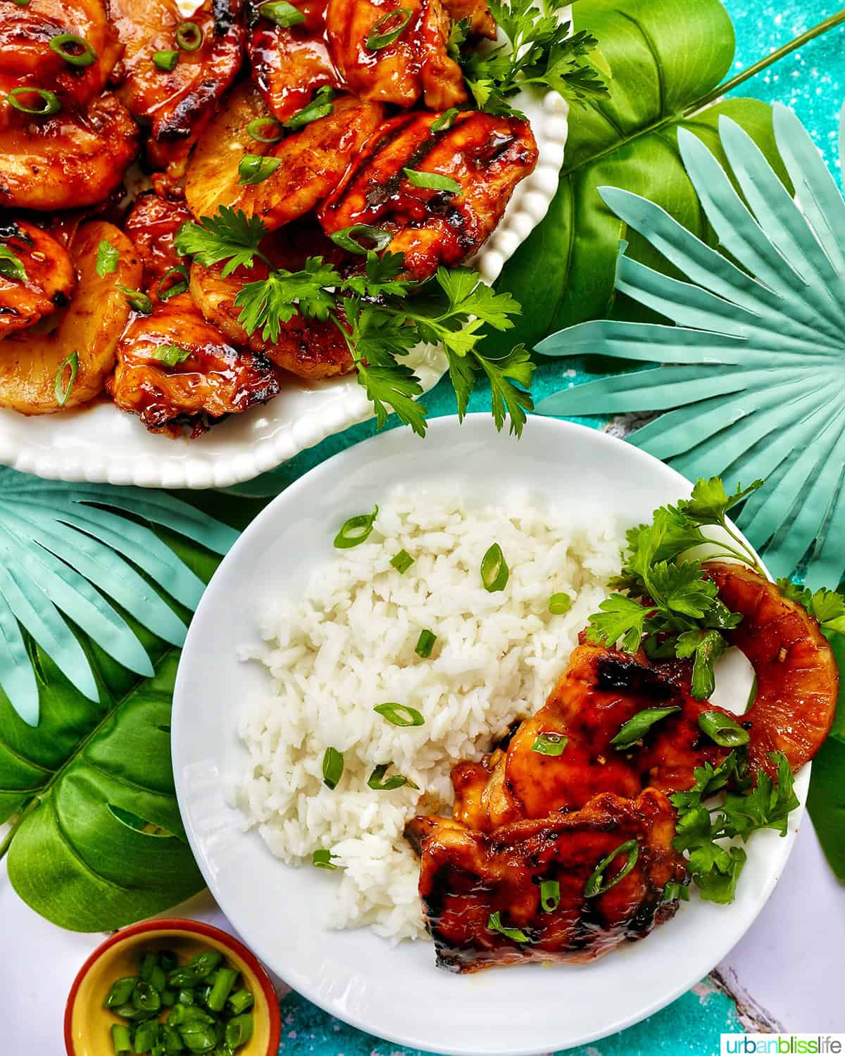 plate of BBQ chicken and pineapples with herbs over rice.