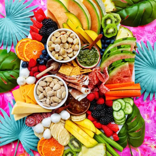 meats, cheeses, crackers, summer fruits and vegetables, nuts, and dips to create a summer charcuterie board.