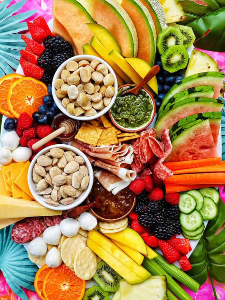meats, cheeses, crackers, summer fruits and vegetables, nuts, and dips to create a summer charcuterie board.