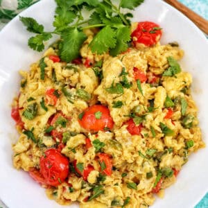 egg vegetable scramble on a white plate with parsley garnish.