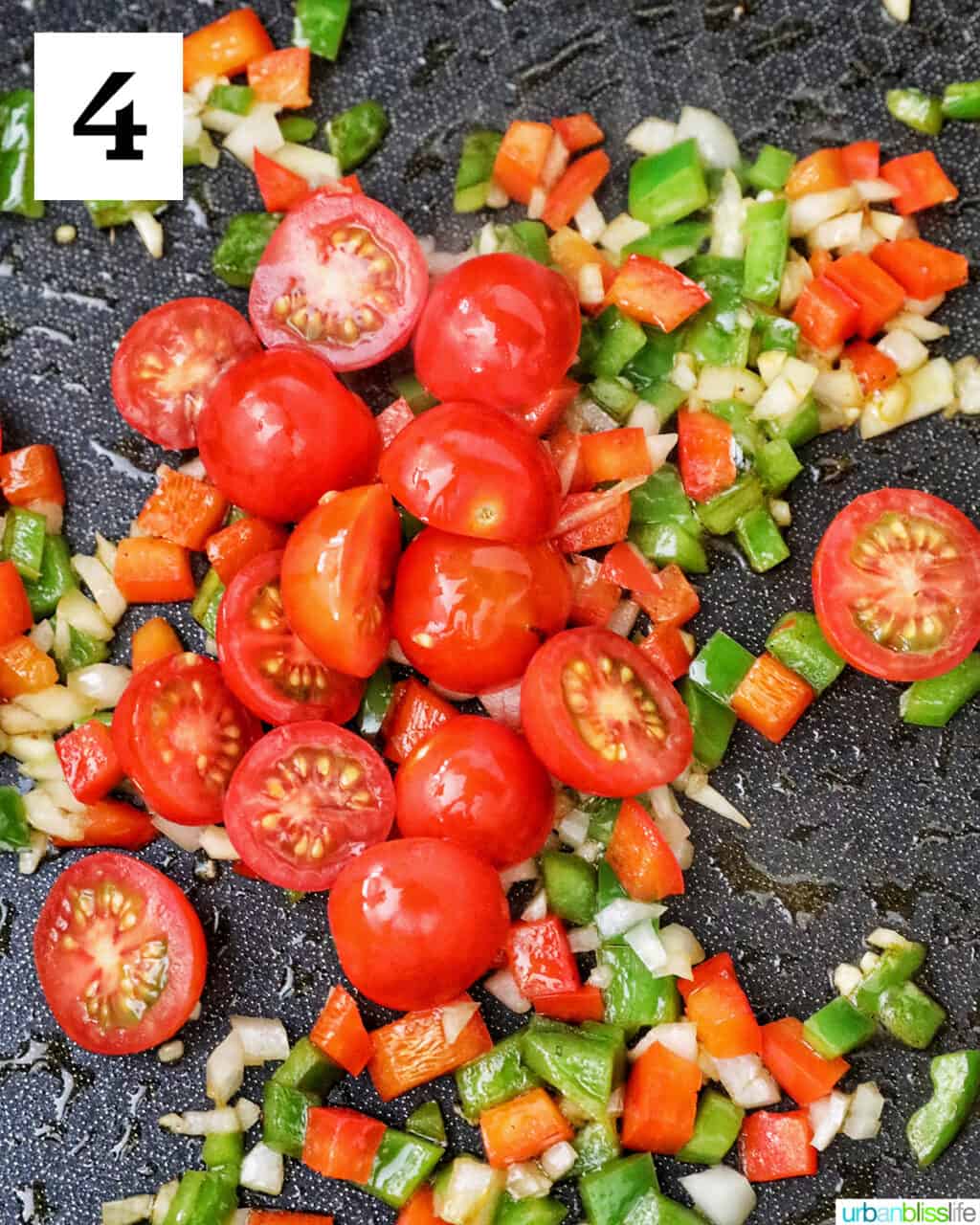 cherry tomatoes, garlic, onions, red bell peppers and green bell peppers in a skillet.