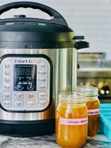 instant pot with jars of chicken stock.