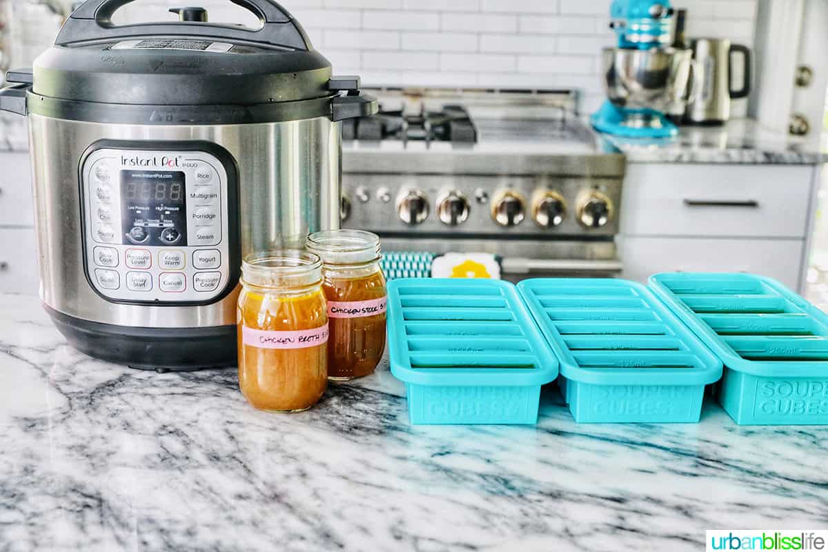 Instant Pot next to mason jars and food storage souper cubes filled with homemade chicken stock.