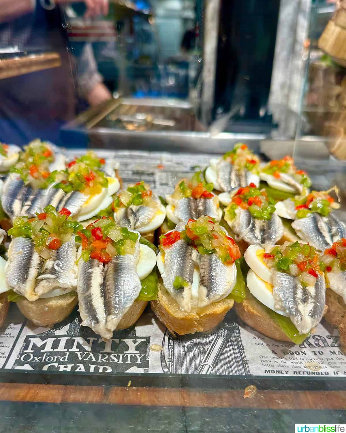 boqueron pintxos - white anchovies - topped with peppers on top of bread.