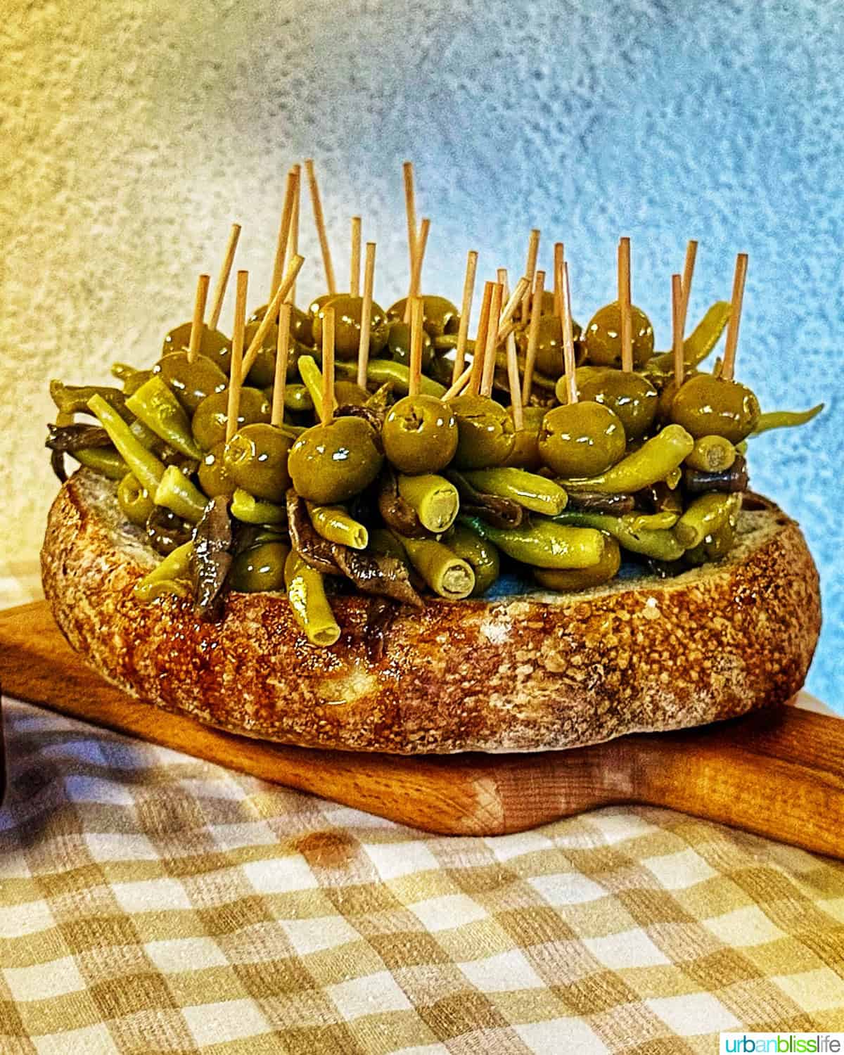 the "gilda" - several skewered olives and peppers in a large round bread bowl.