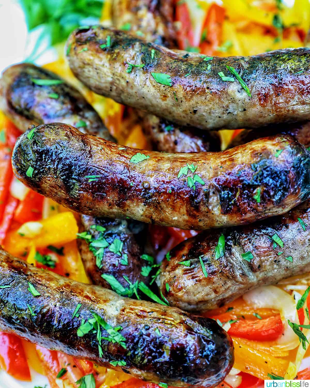 bowl of grilled bratwurst over sauteed peppers.