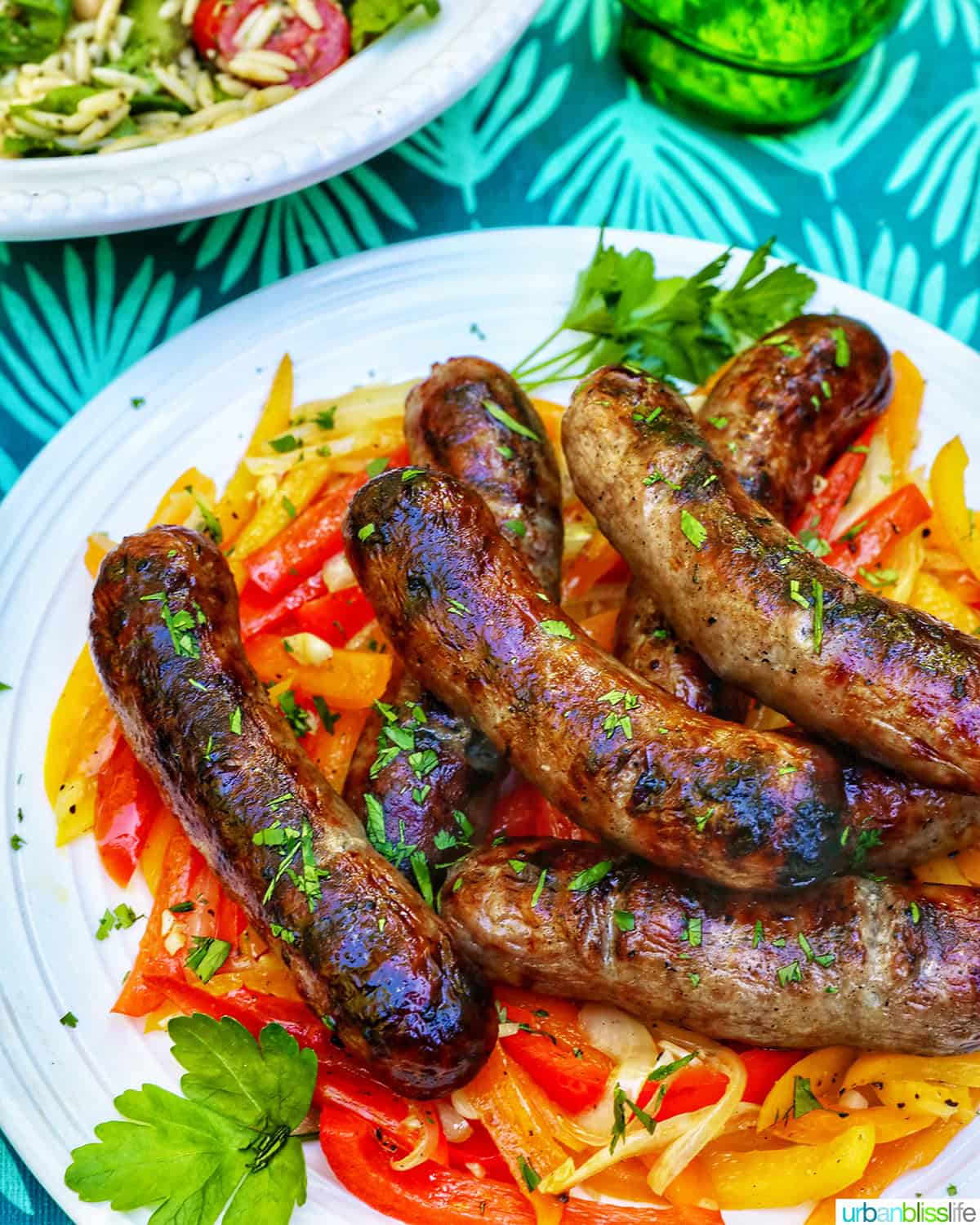 bowl of grilled bratwurst over sauteed peppers.