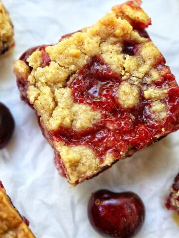 cherry crumble bars surrounded by cherries.