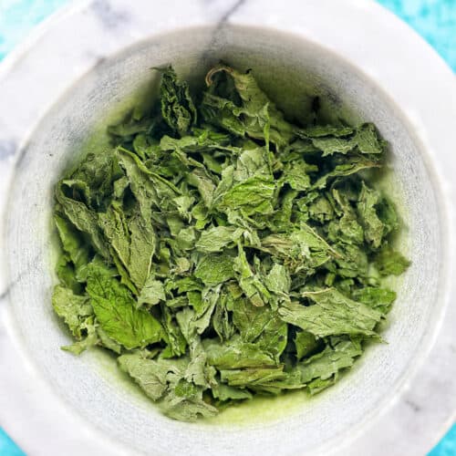 dried mint leaves in a marble bowl.