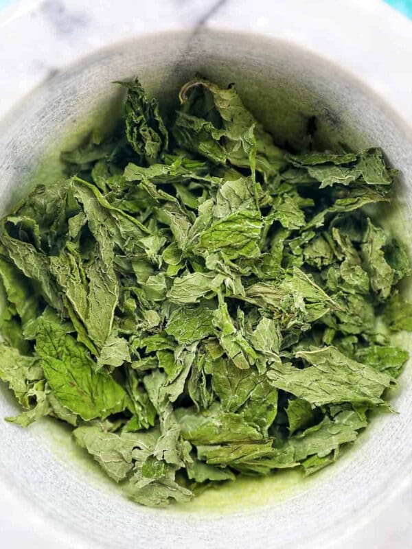 dried mint leaves in a marble bowl.