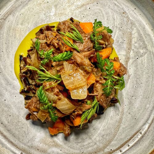 beef and vegetables on a speckled plate.