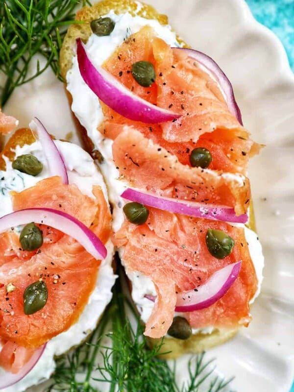 crostini al salmone with garnish of dill on a scalloped plate.