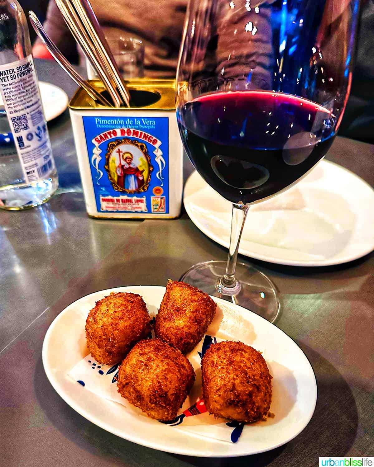 glass of red with with croquetas on a plate at Brindisa in London.