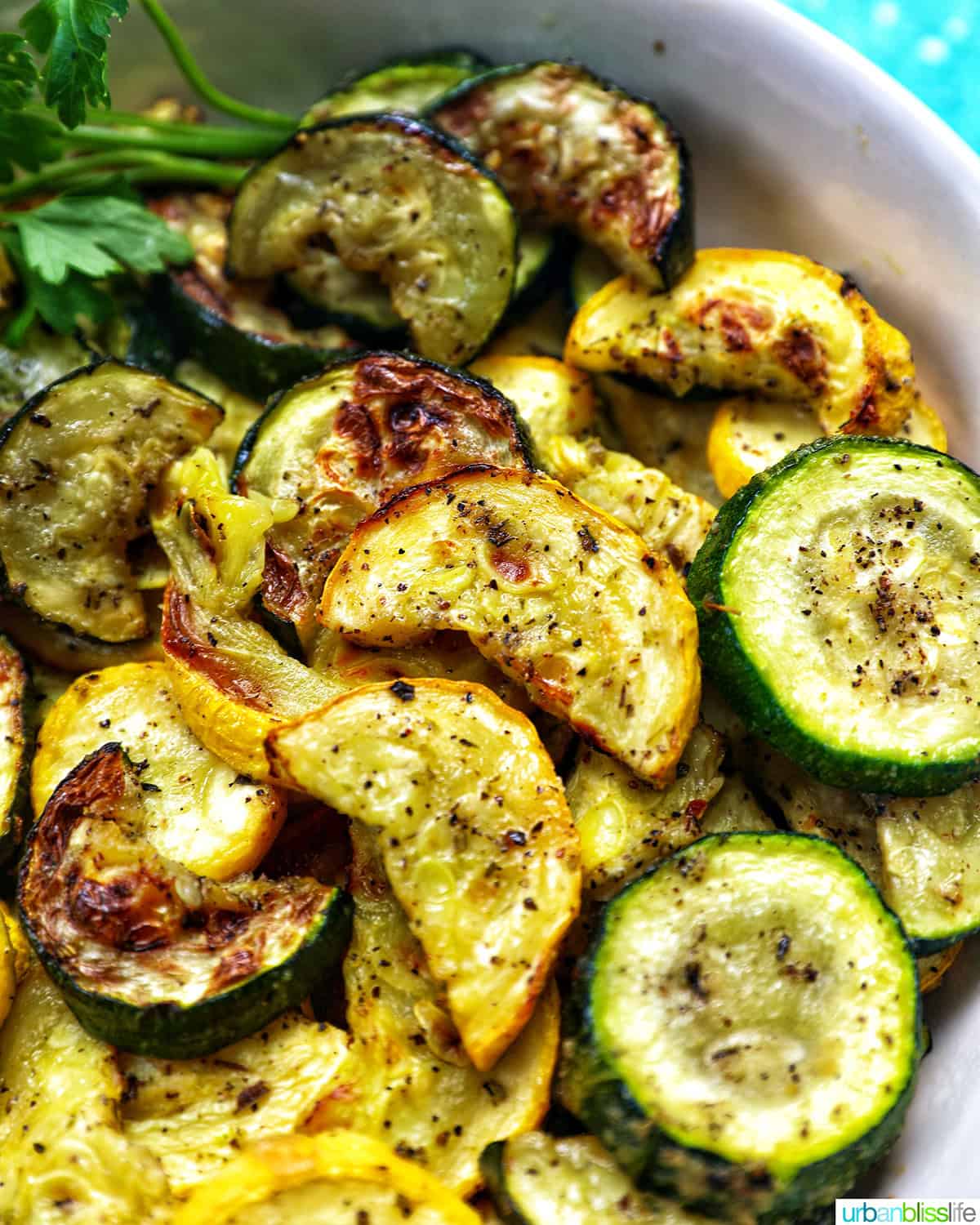 white bowl with air fryer zucchini and yellow squash.