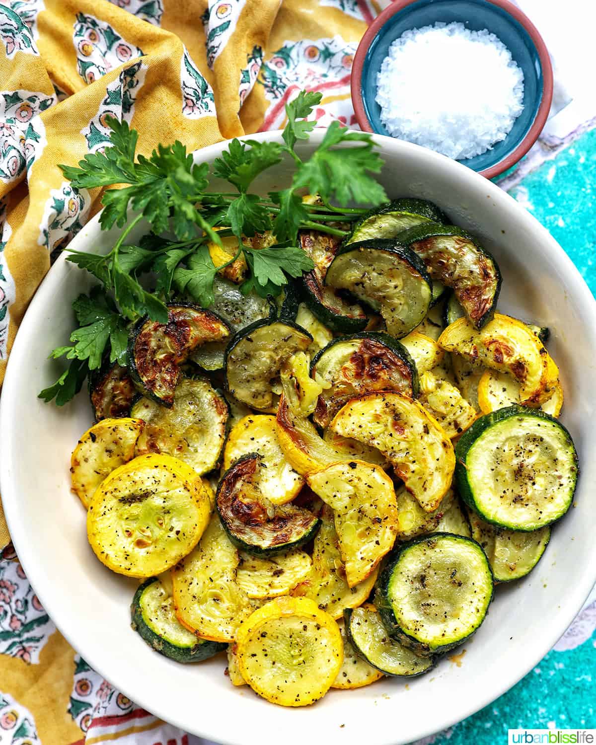 white bowl with air fryer zucchini and yellow squash.