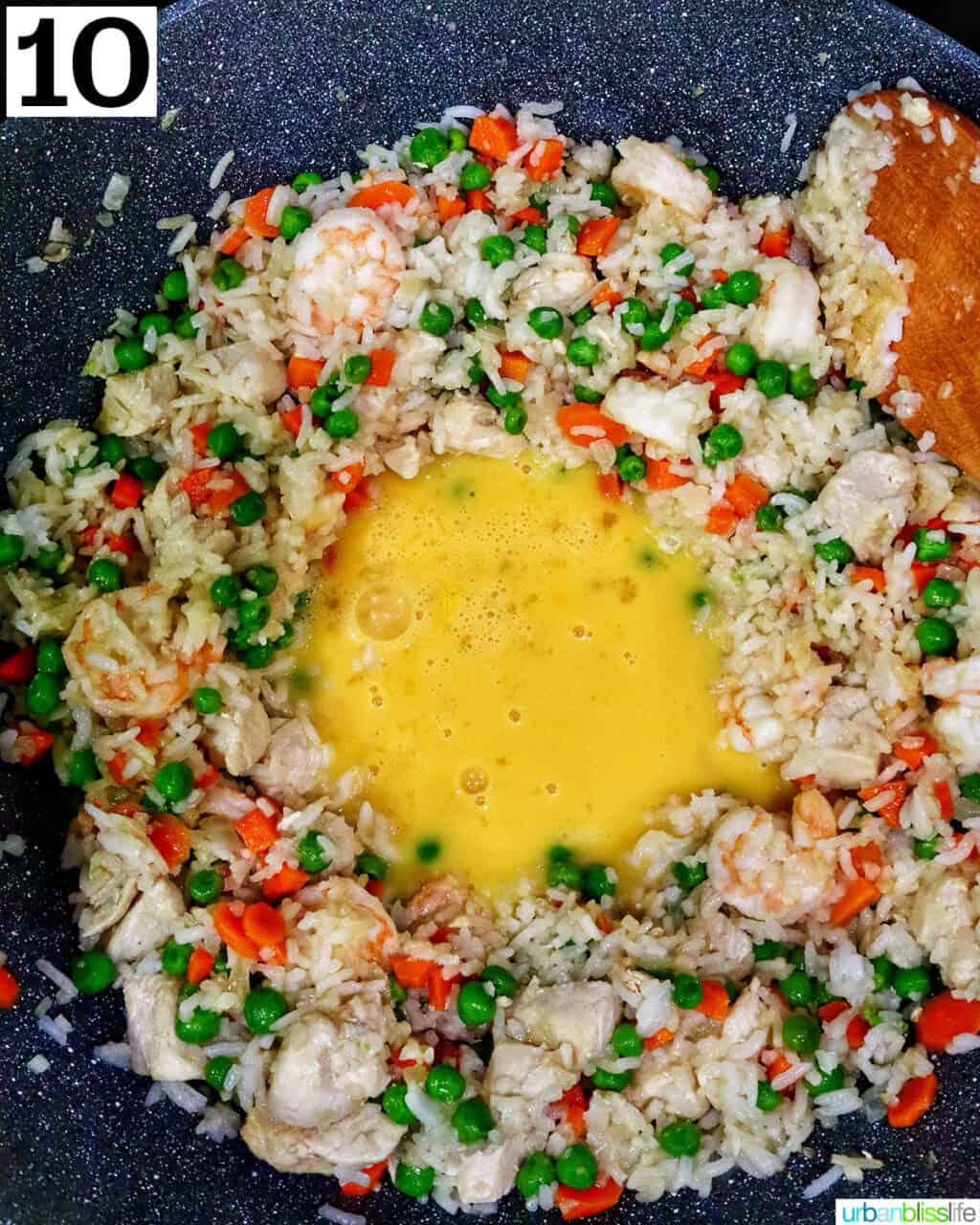 egg added to a wok of shrimp and chicken fried rice.