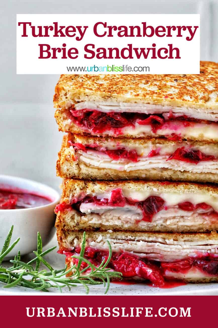 stack of Turkey Cranberry Brie Sandwiches sliced in half with side of cranberry sauce and herbs and title text overlay.