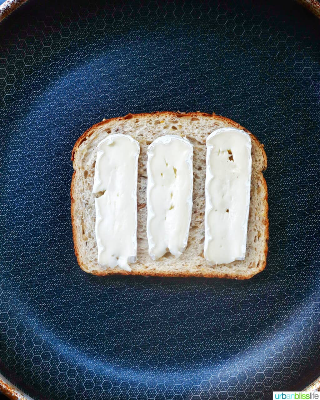 brie slices on bread on a pan.