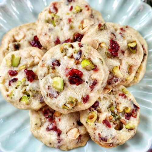 pistachio cranberry shortbread cookies piled onto a plate.