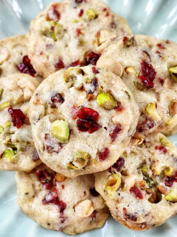pistachio cranberry shortbread cookies piled onto a plate.