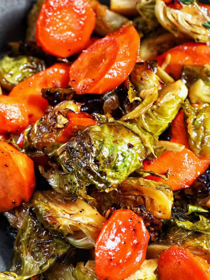 roasted brussels sprouts and carrot slices in a bowl.