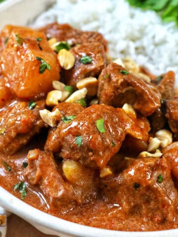 slow cooker beef massaman curry with rice in a bowl.