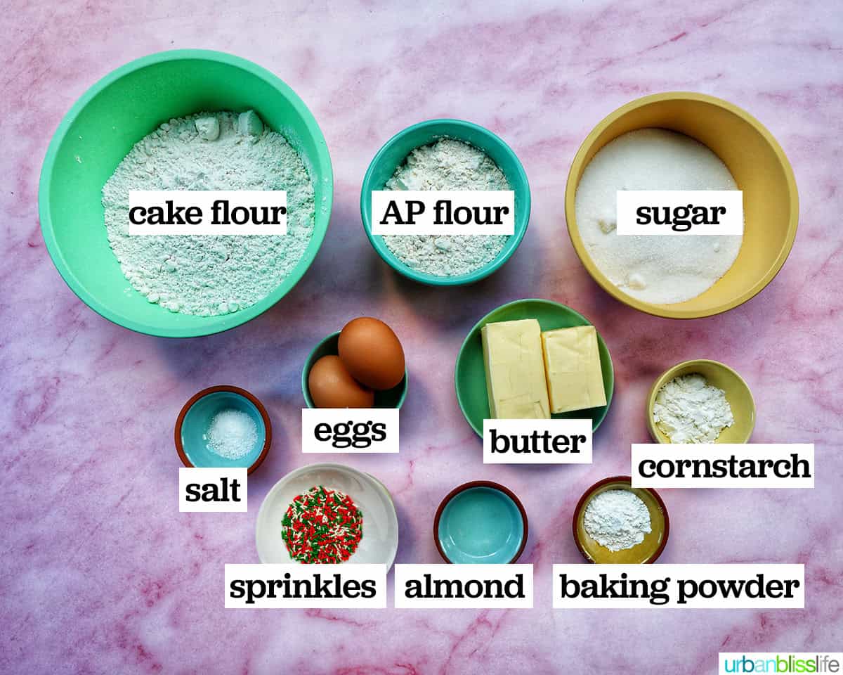 ingredients to make almond Christmas cookies with red and green sprinkles.