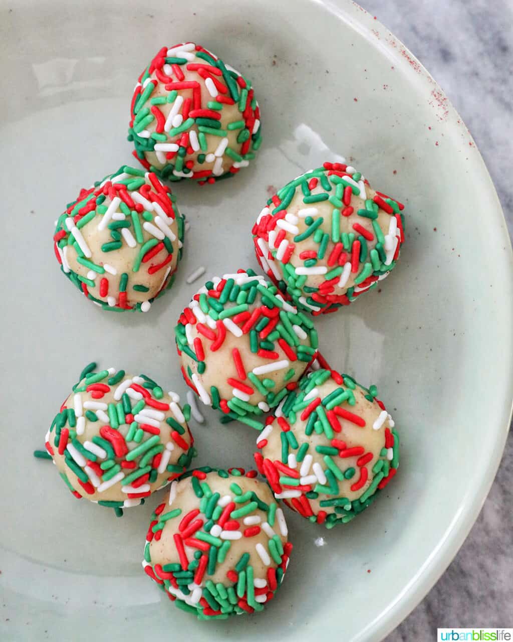 almond cookie balls coated with red, green and white Christmas sprinkles.