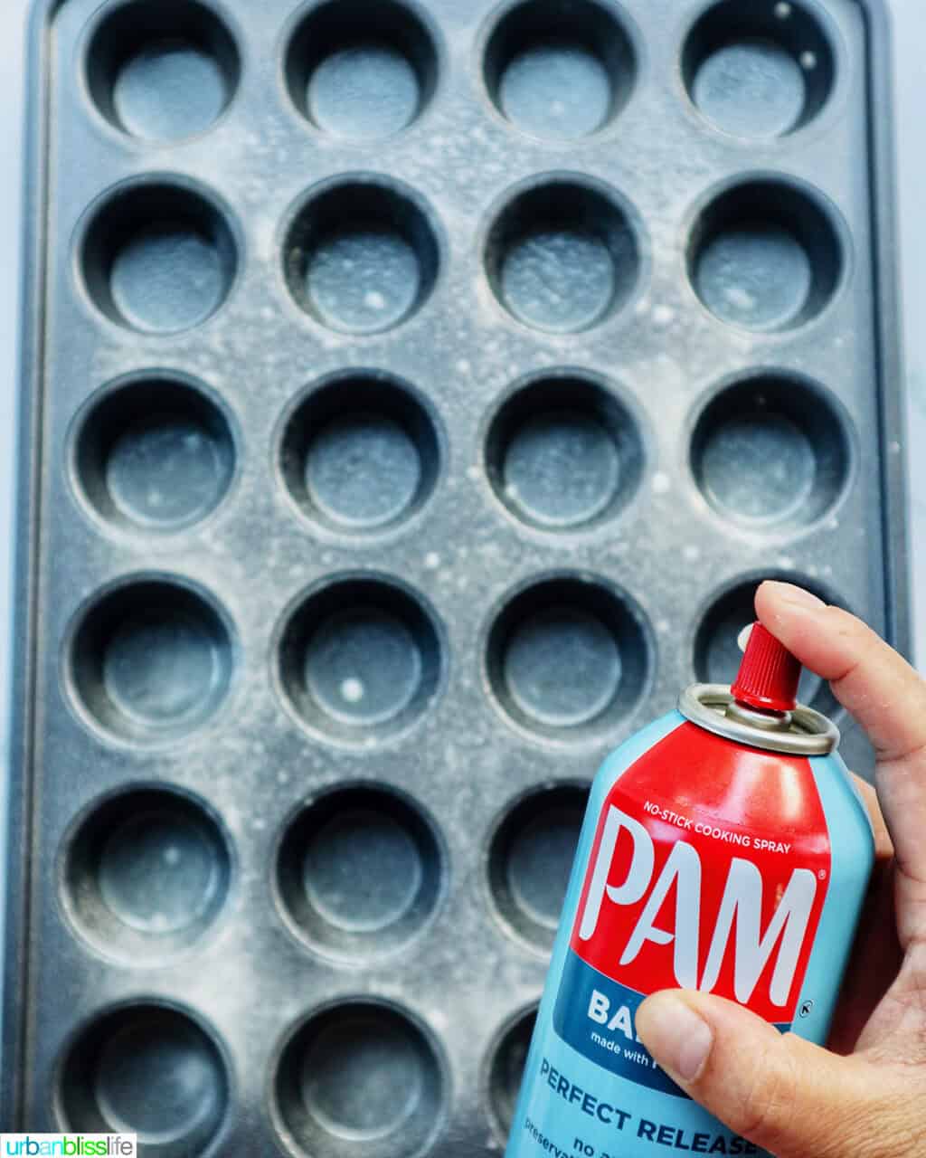 spraying a muffin tin with cooking spray.