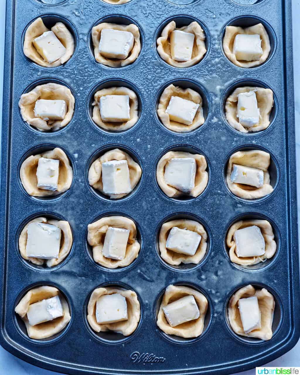 cranberry brie tartlets in a muffin tin.