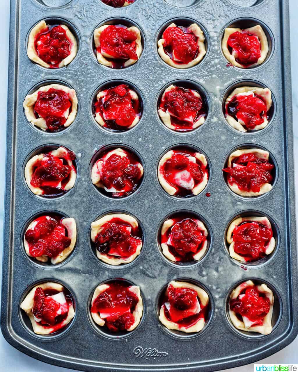 cranberry brie tartlets in a muffin tin.