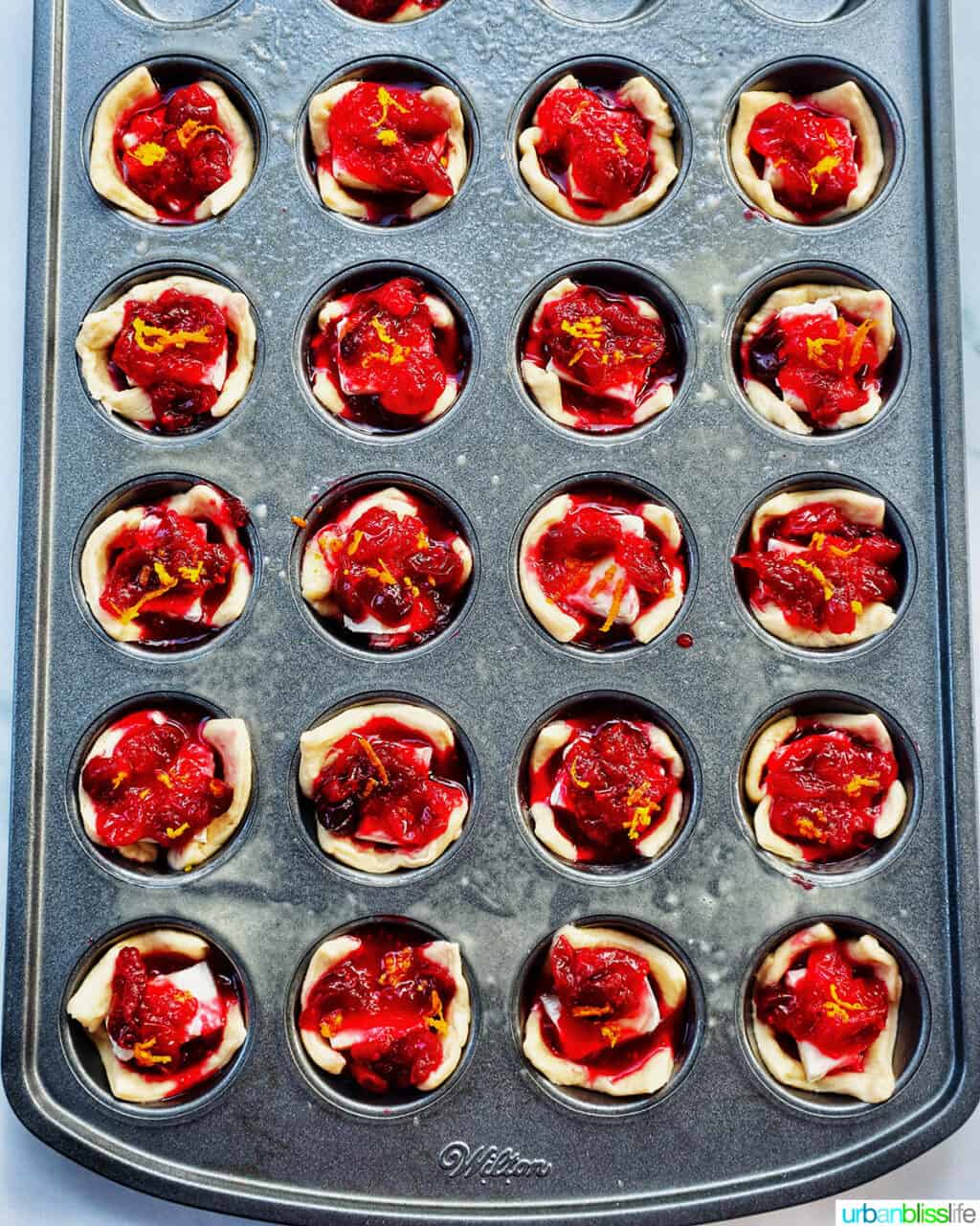 cranberry brie tartlets in a muffin tin.