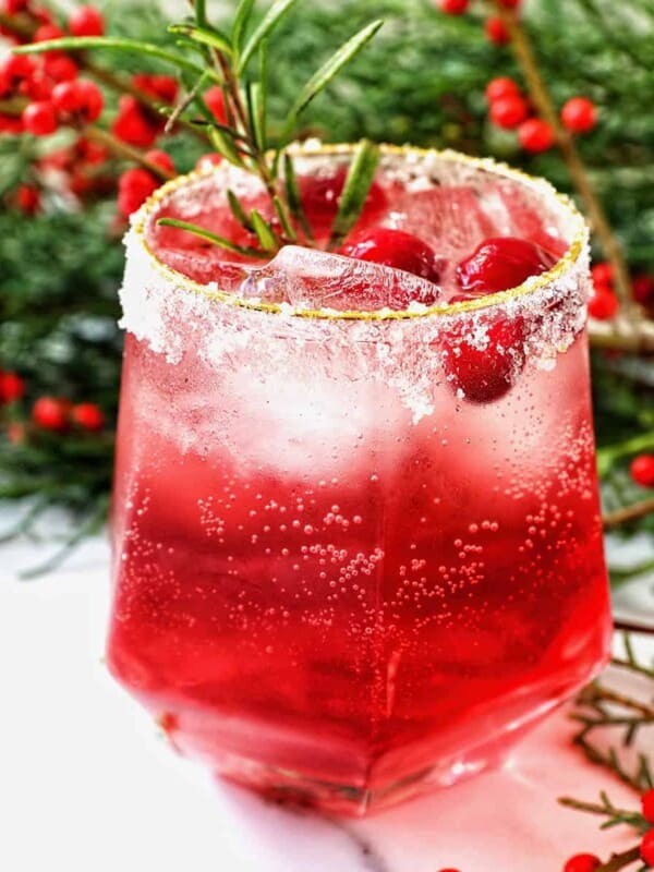 glass of cranberry mocktail drink with festive christmas decorations.