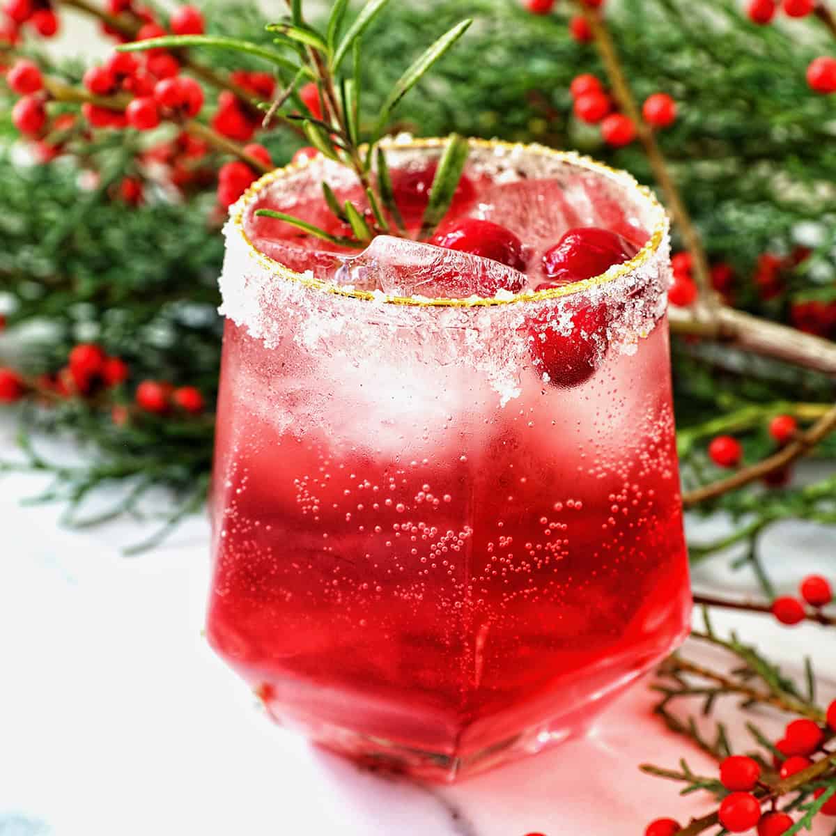 glass of cranberry mocktail drink with festive christmas decorations.