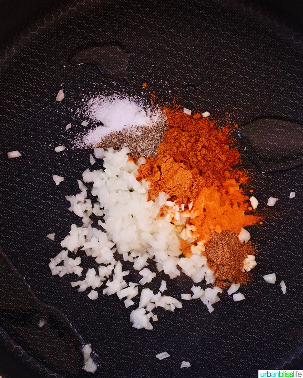 curry spices and minced garlic in a pan.